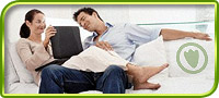 This is an image of a couple on a couch smiling and looking at a laptop computer. 
		    The Jade Penguin logo is embedded on one of the pillows :)
